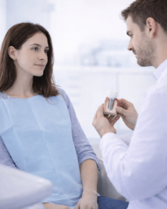 Un médecin qui montre a un patient un implant