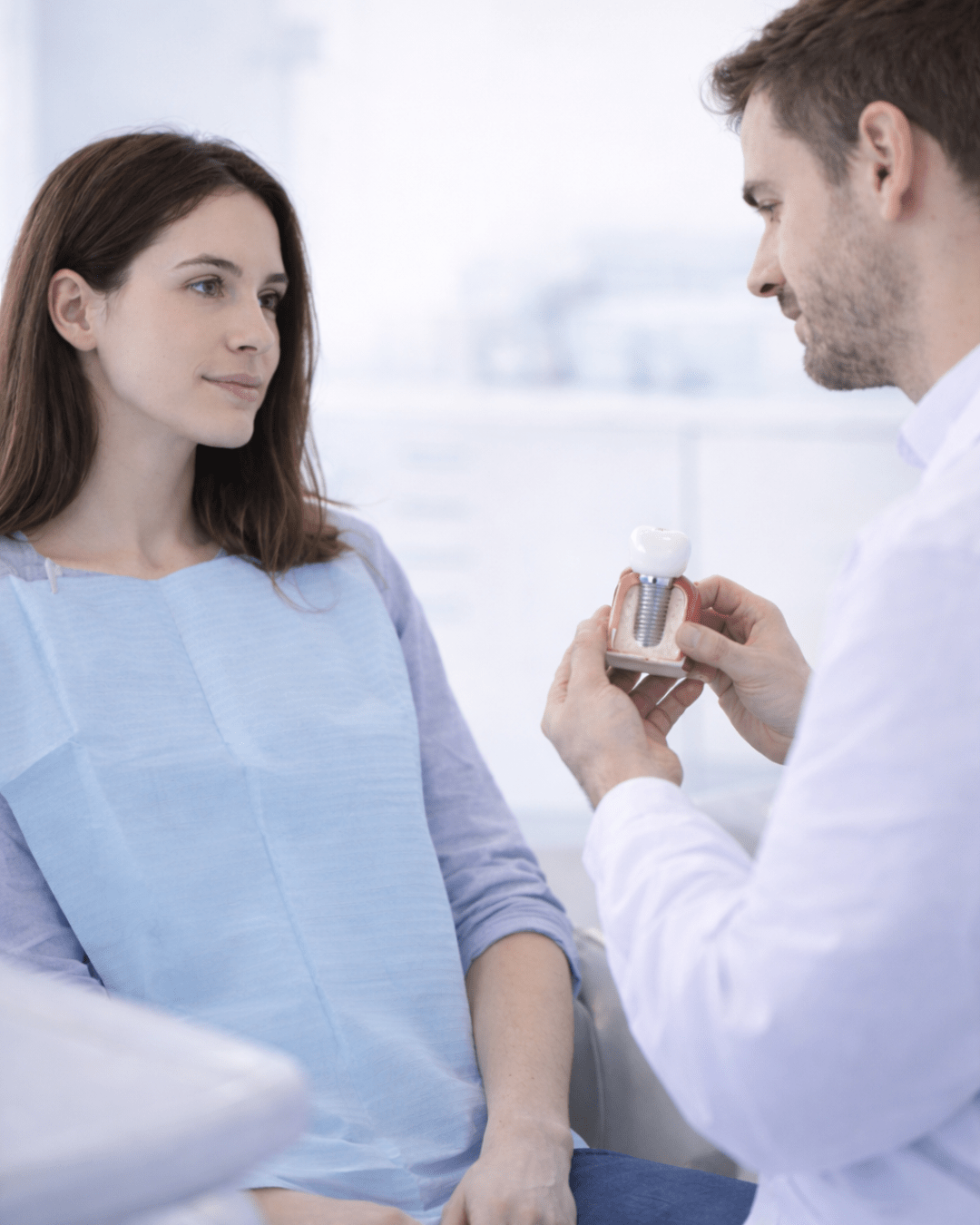 Un médecin qui montre a un patient un implant