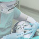 Médecin qui applique des soins fluorés à un patient jeune