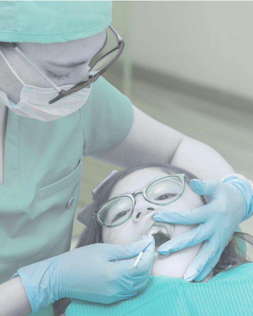 Médecin qui applique des soins fluorés à un patient jeune